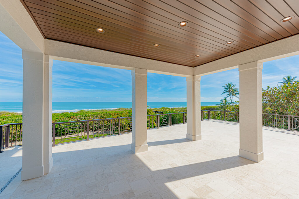 Indoor-outdoor living space with sliding glass walls in Florida home by Florida Interior Designer Tracie Annase