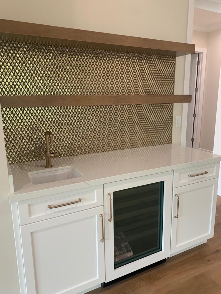 Mosaic backsplash with metallic accents in home bar area